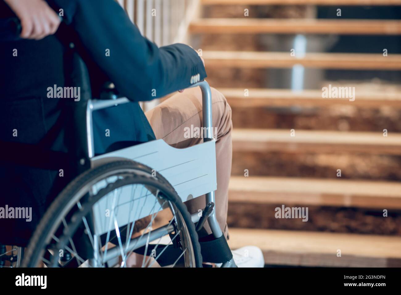 Man in wheelchair stopped near stairs Stock Photo