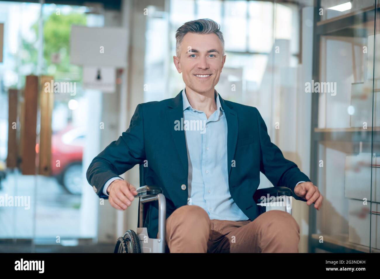Happy smiling man on wheelchair indoors Stock Photo