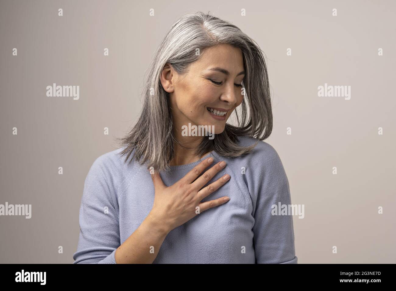 Charming Asian woman is touching her chest Stock Photo