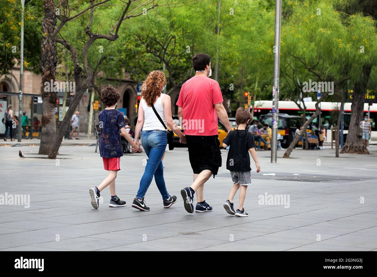Family of four walking hand in hand, Barcelona, Spain. Stock Photo