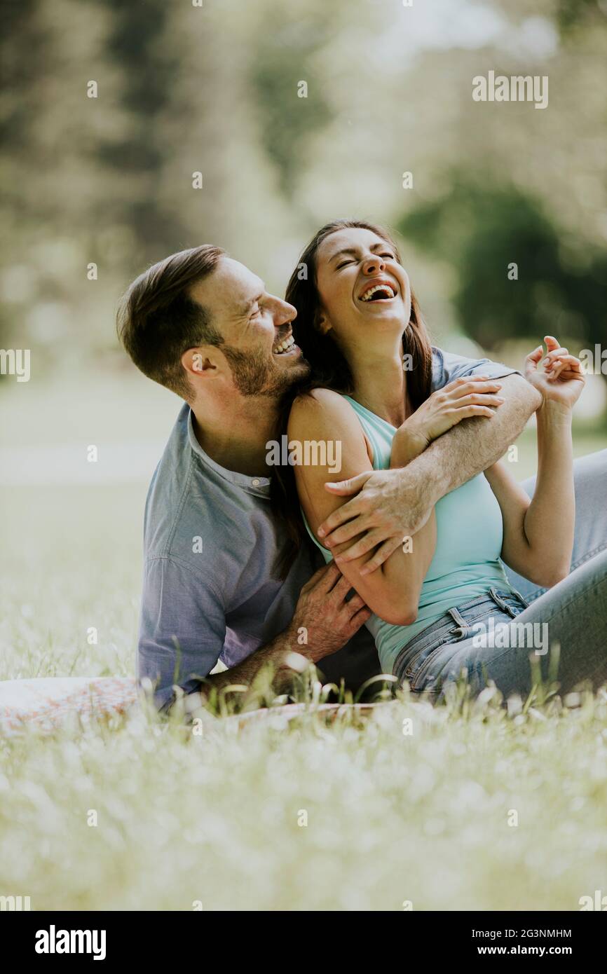 Affectionate young couple sitting on the green grass at the park Stock ...