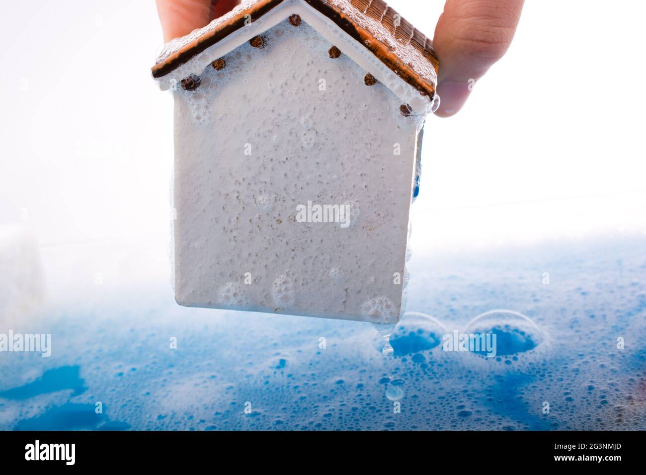 Model house in hand in foamy water Stock Photo