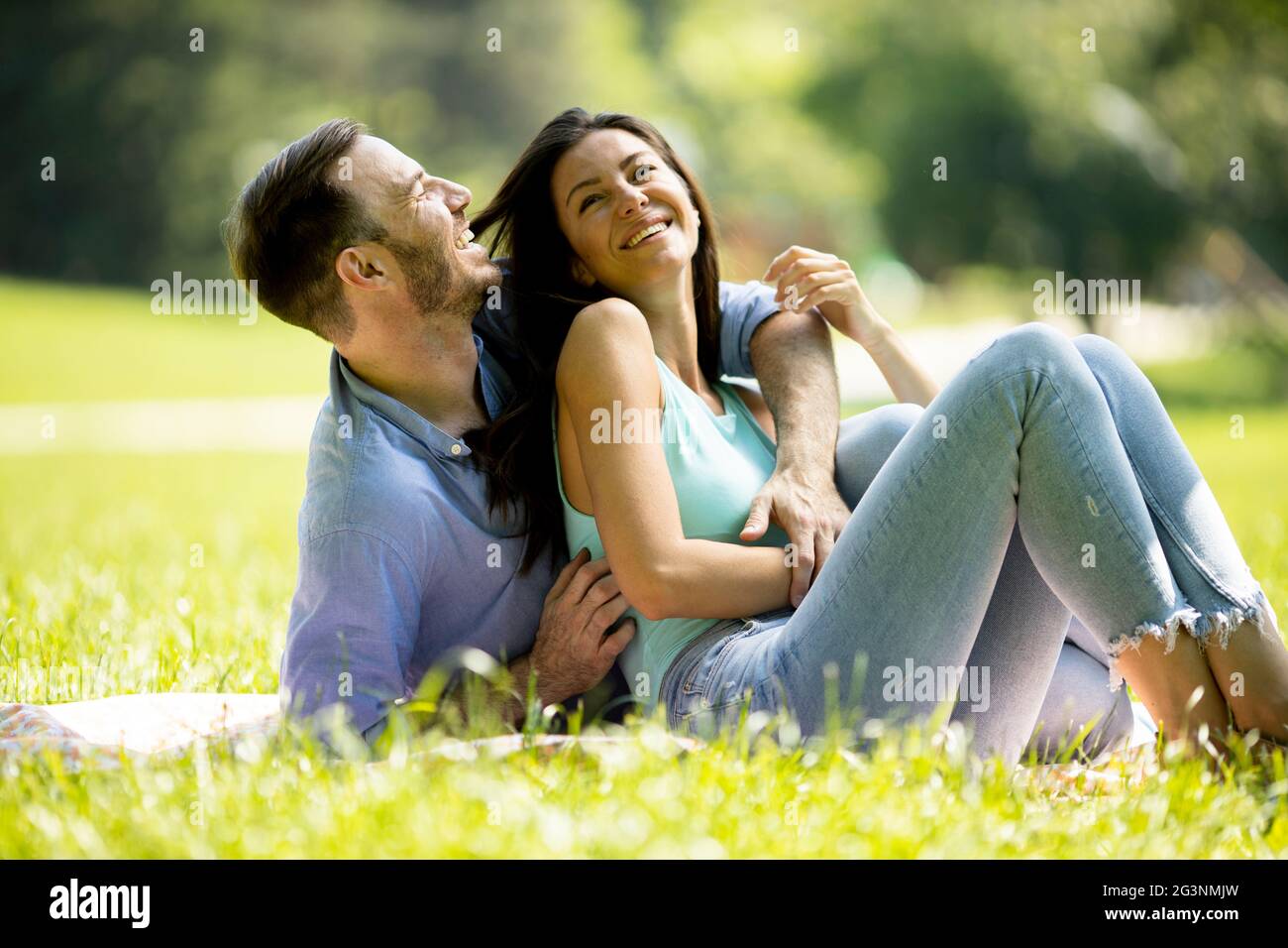 Affectionate young couple sitting on the green grass at the park Stock ...