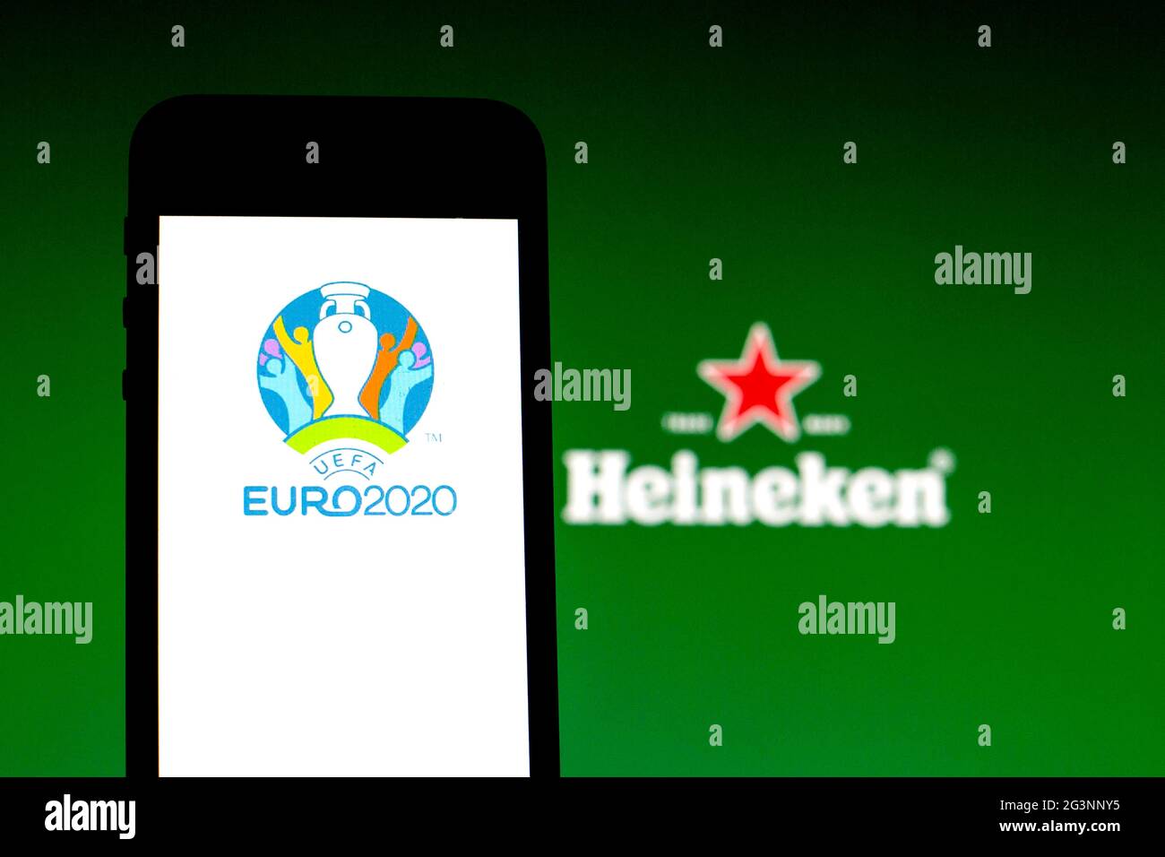 In this photo illustration a UEFA Euro 2020 logo seen displayed on a smartphone with a Heineken logo in the background. Stock Photo