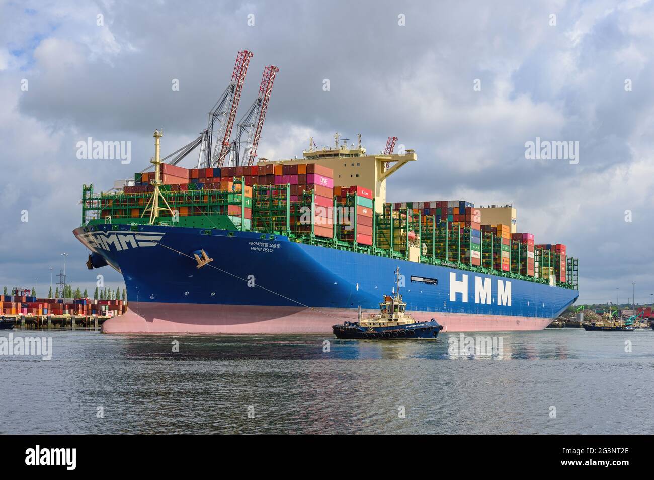 The container ship HMM Oslo is assisted by tugs on departure from the Port of Southampton - May 2021 Stock Photo