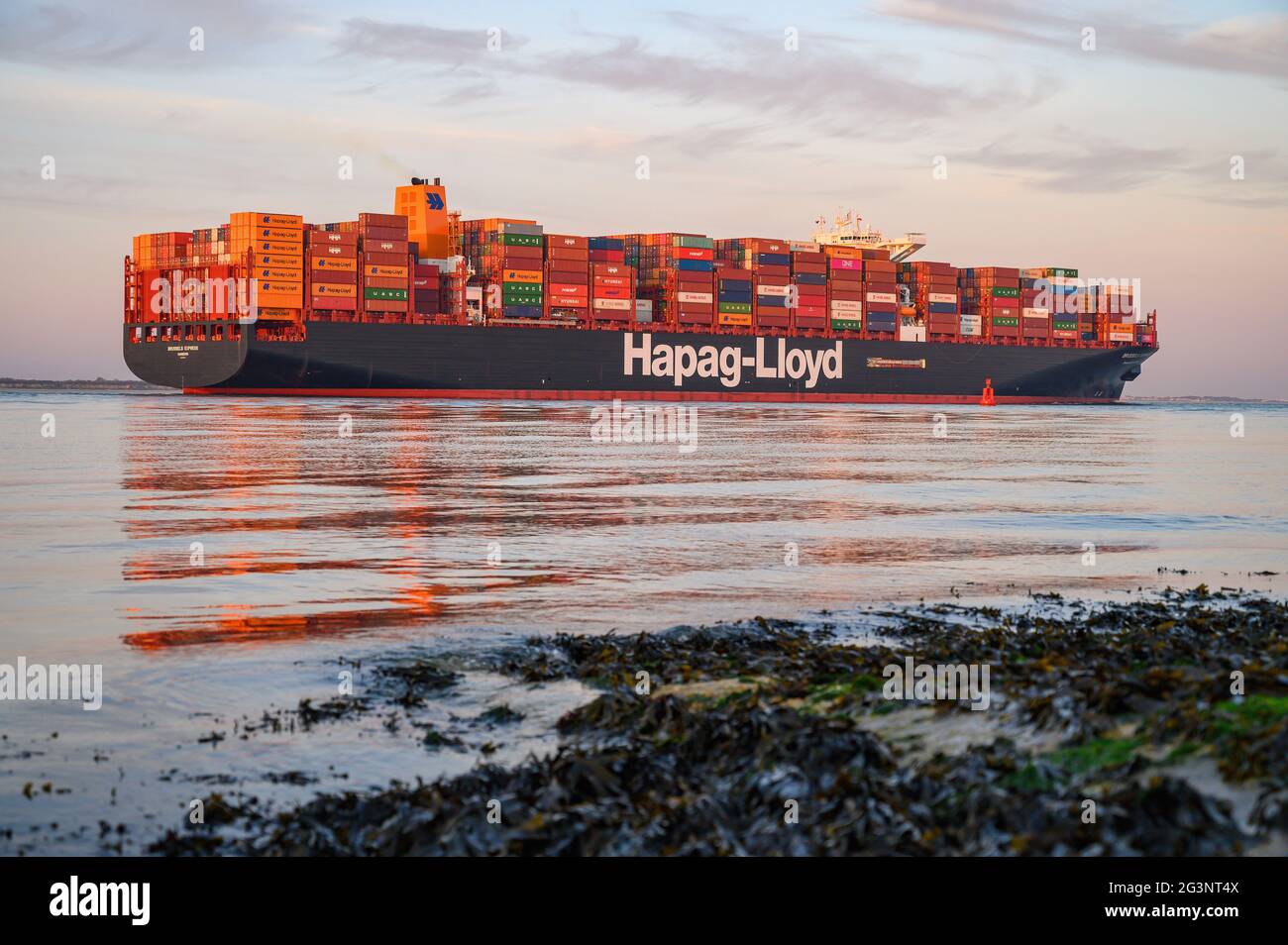 A sunset view of the LNG-powered container ship Brussels Express on Southampton Water - June 2021 Stock Photo