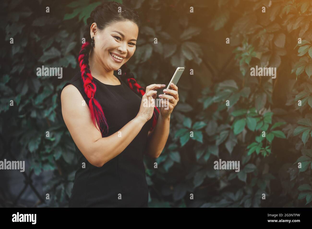 Beautiful Mature Asian Female Model with Smartphone Outdoor Stock Photo