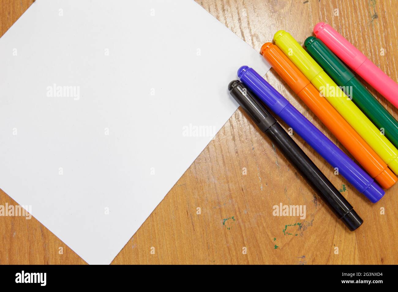 A set of colored markers and a sheet of white paper on the table Stock Photo - Alamy