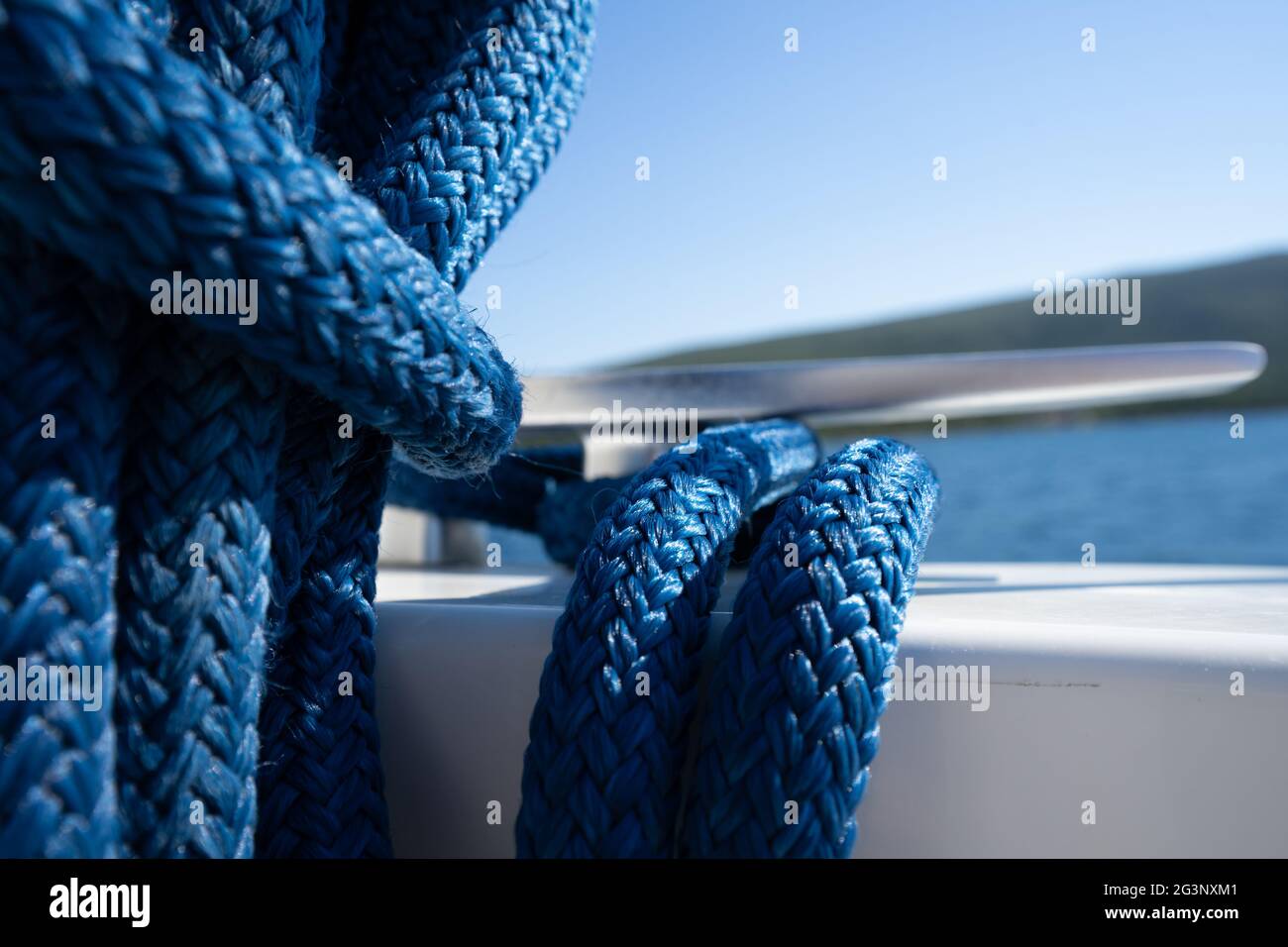 blue double braided marine rope on a cleat of the yacht Stock Photo - Alamy