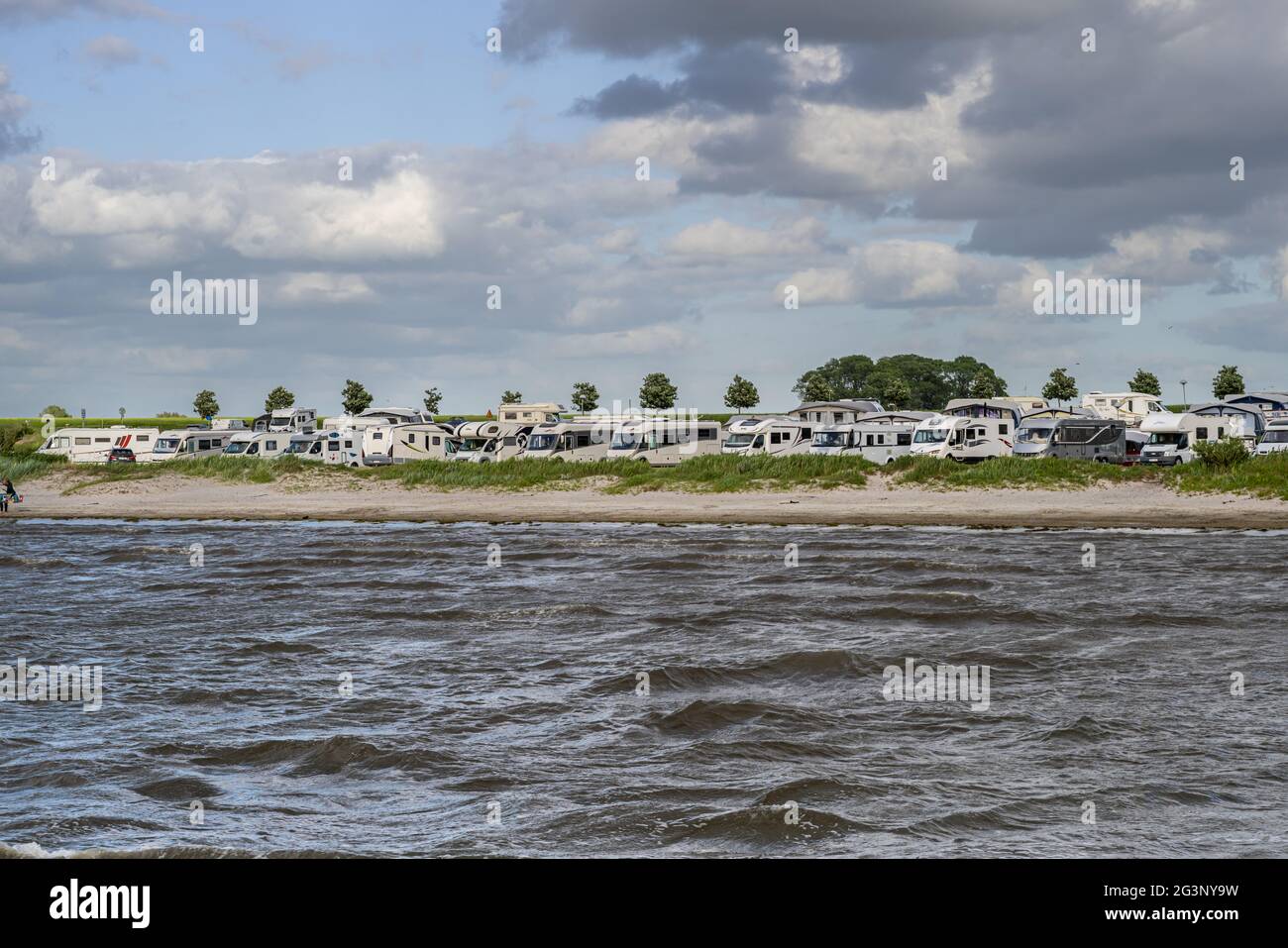 June 13, 2021 - Malmo, Sweden: RVs parked by a beach a windy summer day. The sales of RVs have increased since the pandemic has made international travel more difficult Stock Photo