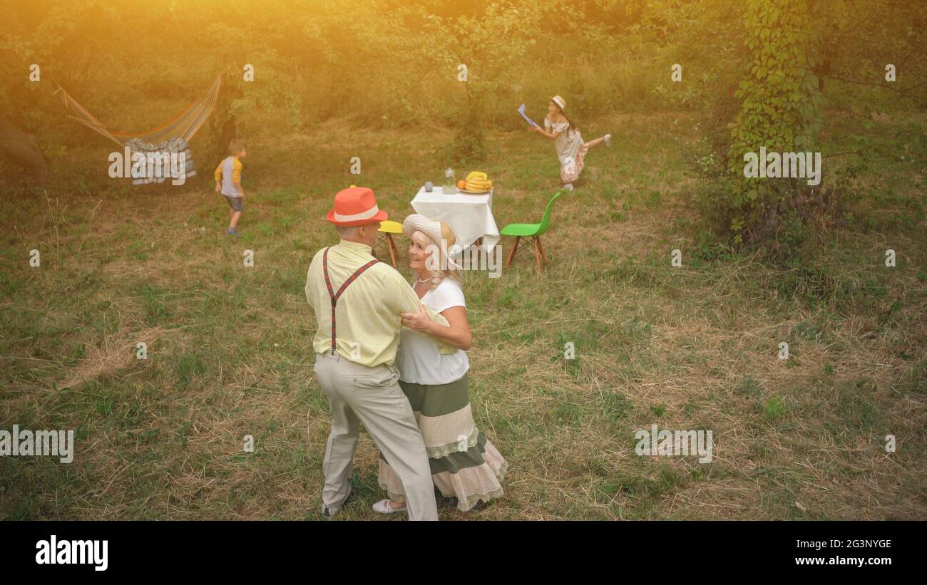 The Old Lady And Gentleman Dancing In The Garden Stock Photo