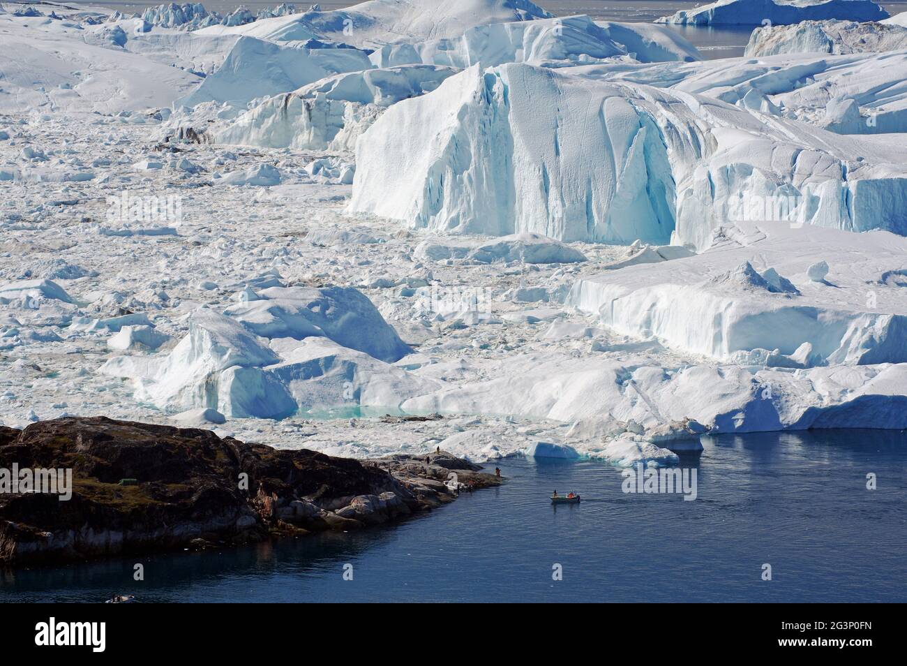 Boat in front of glacier - Ilulissat Stock Photo