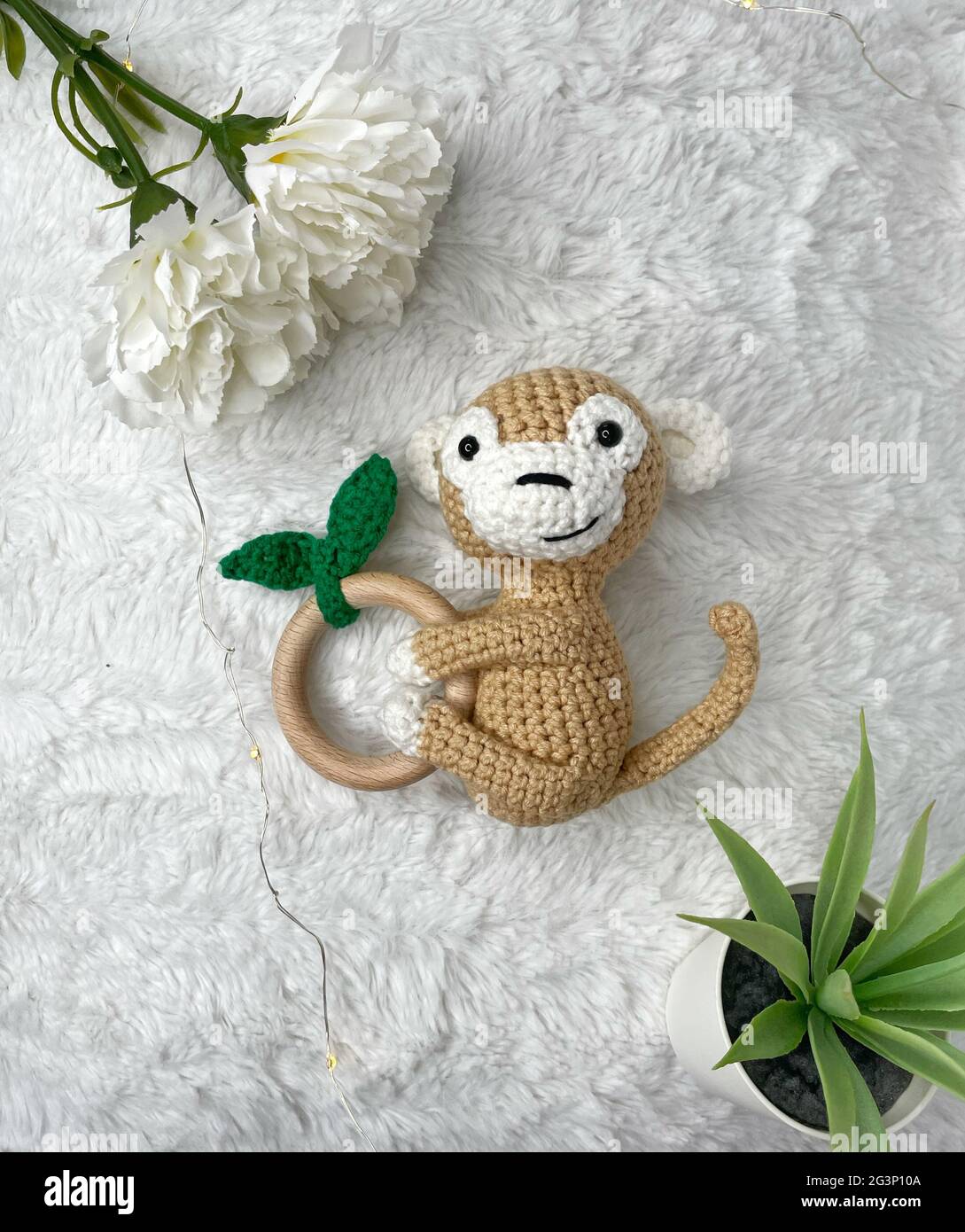 Handmade Crochet Animal Toy - Amigurumi Stuffed Toy - Crochet Monkey Wooden Teether for Babies Stock Photo