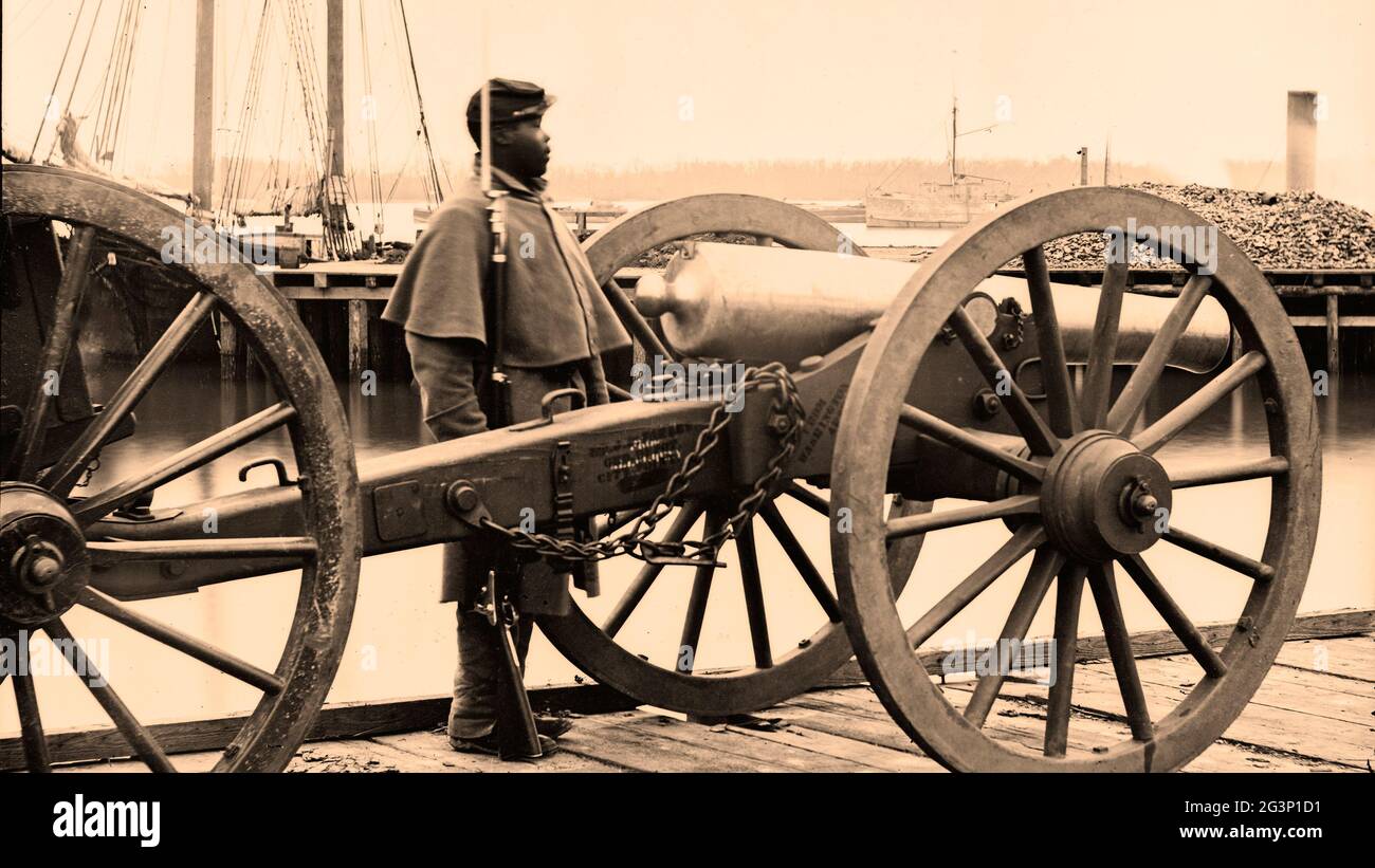 An African American Civil War soldier guarding U.S. Model 1857 12-pdr. Napoleon canon between 1862 and 1865 at City Point, VA Stock Photo