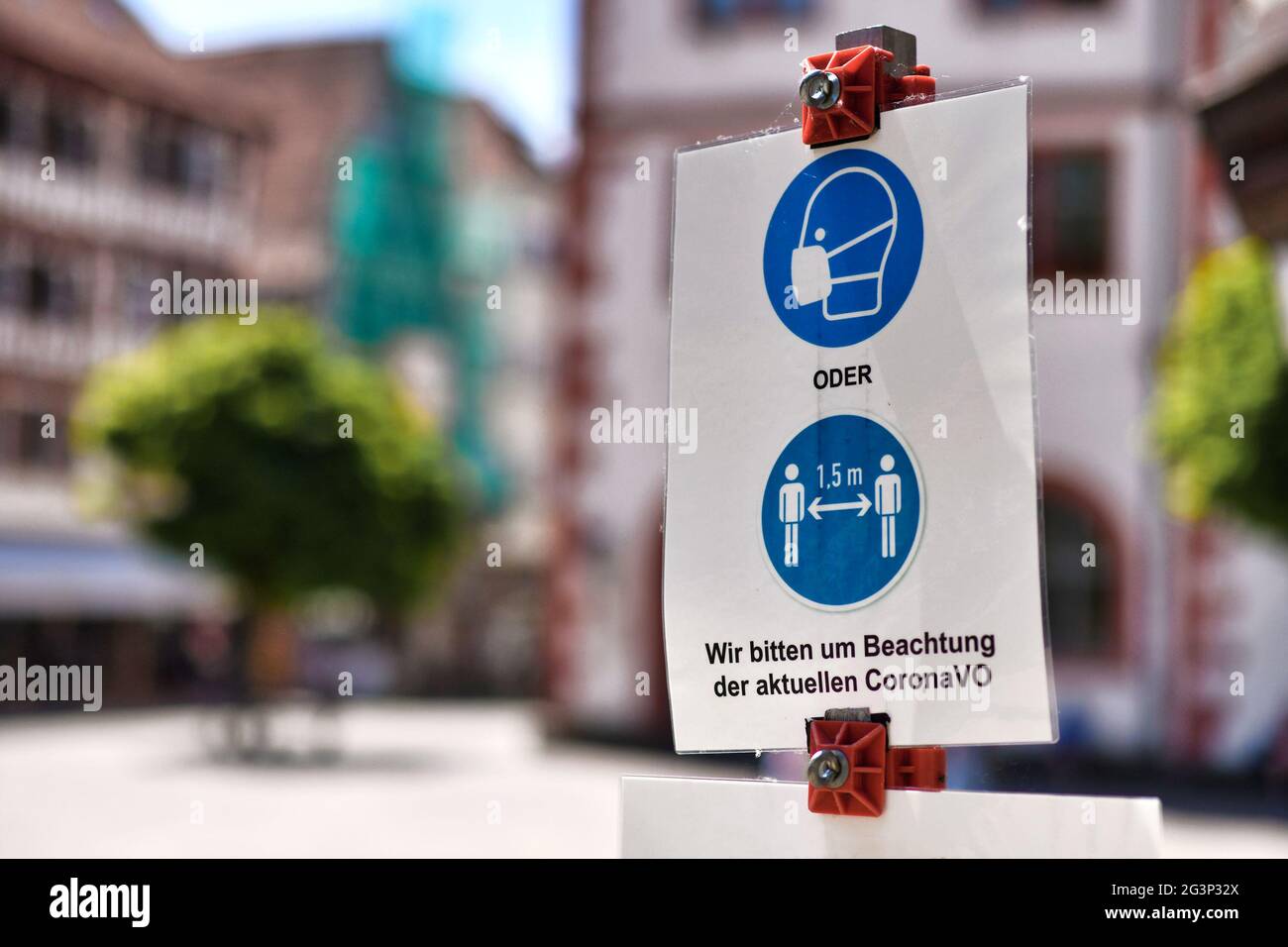 Mosbach, Germany - June 2021: Signs for face mask and distance requirement in German city with text saying 'Please pay attention to current Corona reg Stock Photo