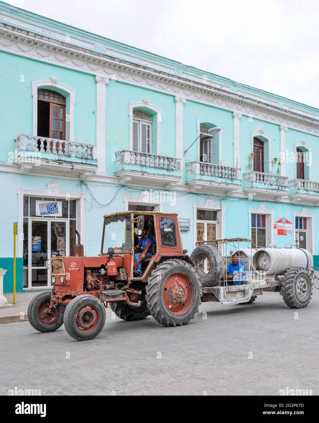 Cuban images: Old soviet tractor pulling a trailer on the street Cuban city Stock Photo