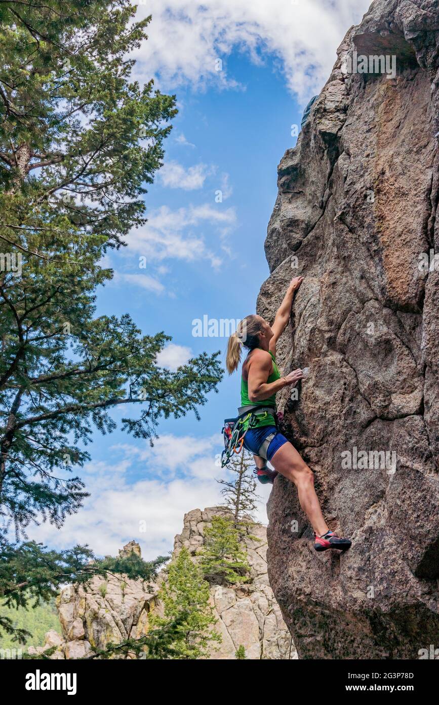 6/6/21 - Boulder, Colorado - A woman works out the moves on a difficult rock climb in Boulder Canyon Stock Photo