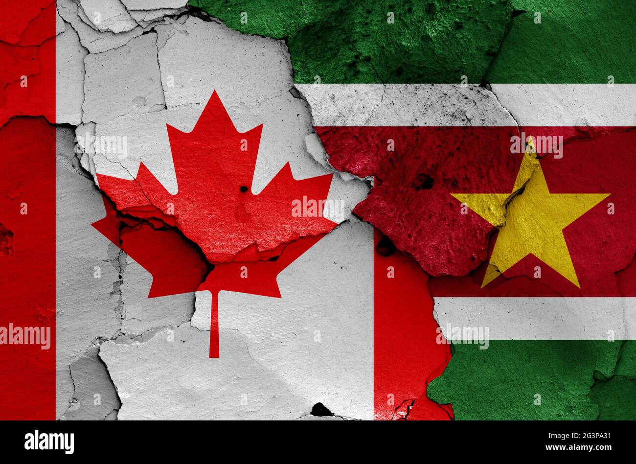 flags of Canada and Suriname painted on cracked wall Stock Photo