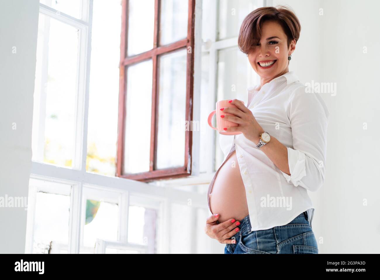 Pregnant Woman Waiting For Unborn Baby Smiles Indoor Stock Photo