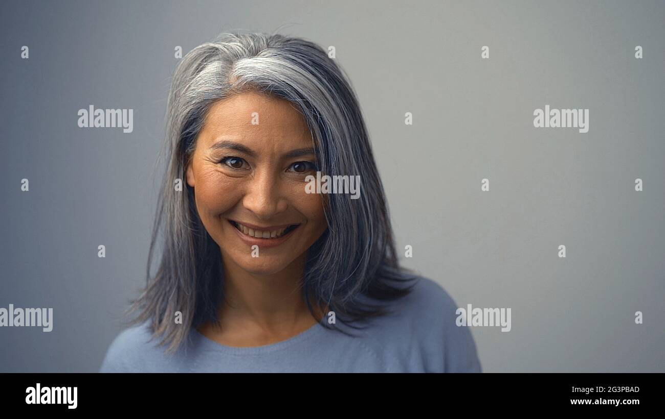 Smiling Asian Woman With Wrinkles Near Her Eyes Stock Photo
