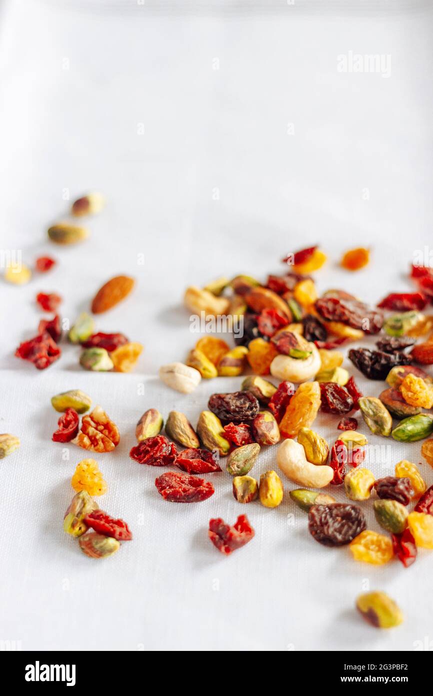 Dried fruit and nuts trail mix, closeup, on silver tray on white Stock Photo