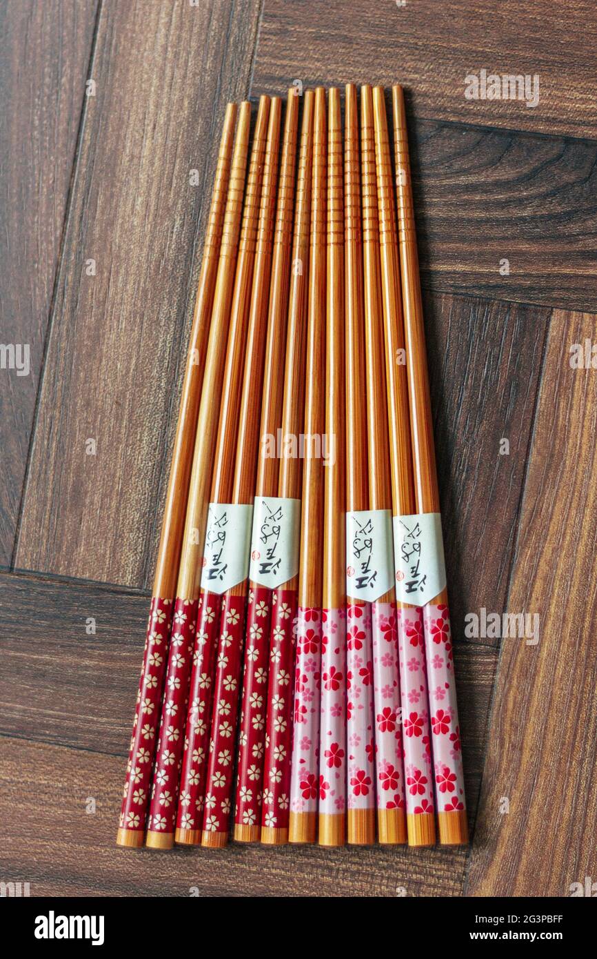 Group of Pink Floral Chopsticks with Chinese Script on Wooden Geometric Background - FOODPIX Stock Photo