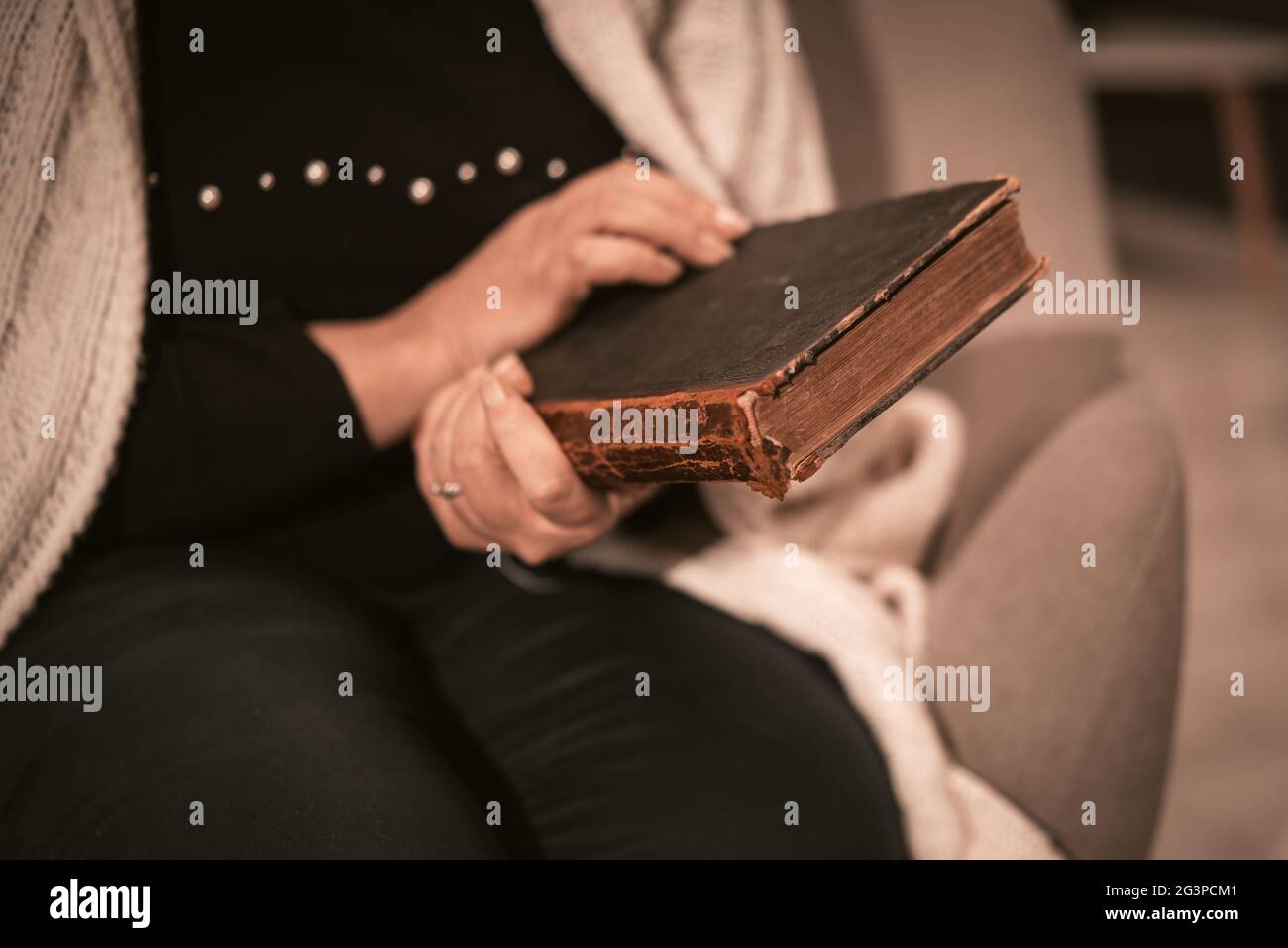 Elderly Caucasian Woman Holds An Antique Book In Her Hands Stock Photo