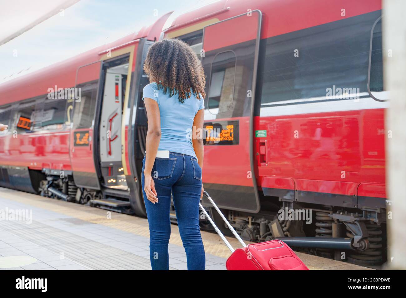 Afro woman ready to take the train with carry on baggage trolley Stock Photo Alamy