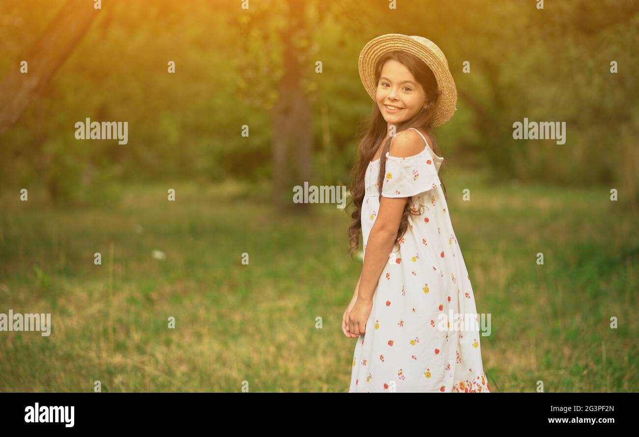 Smiling Girl Spinning in White Dress in Garden. Stock Photo