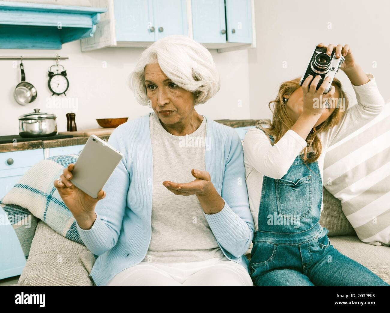 Grandma And Her Grandchild Cannot Understand Each Other's Gadgets Stock Photo