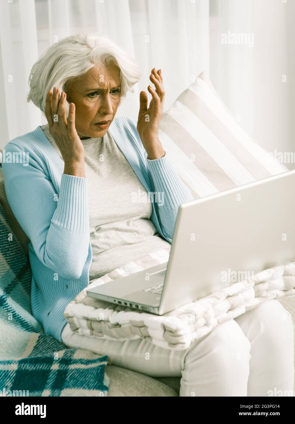 Frustrated Senior Woman Having Difficulty Using Laptop Computer Stock Photo