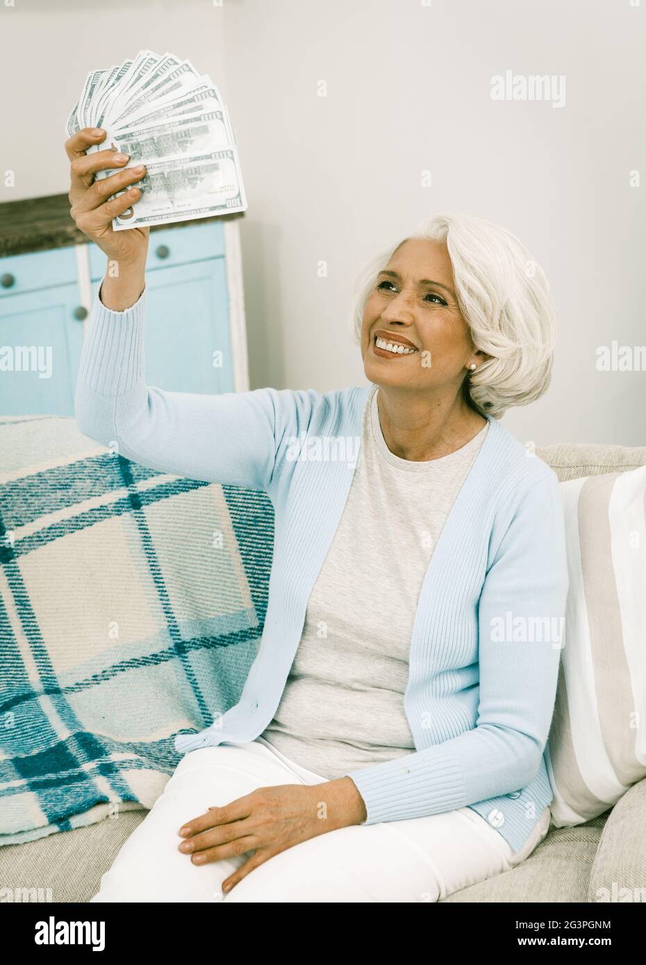 Joyful Lady of Retirement Age Holds a Large Amount of Cash Notes Stock Photo