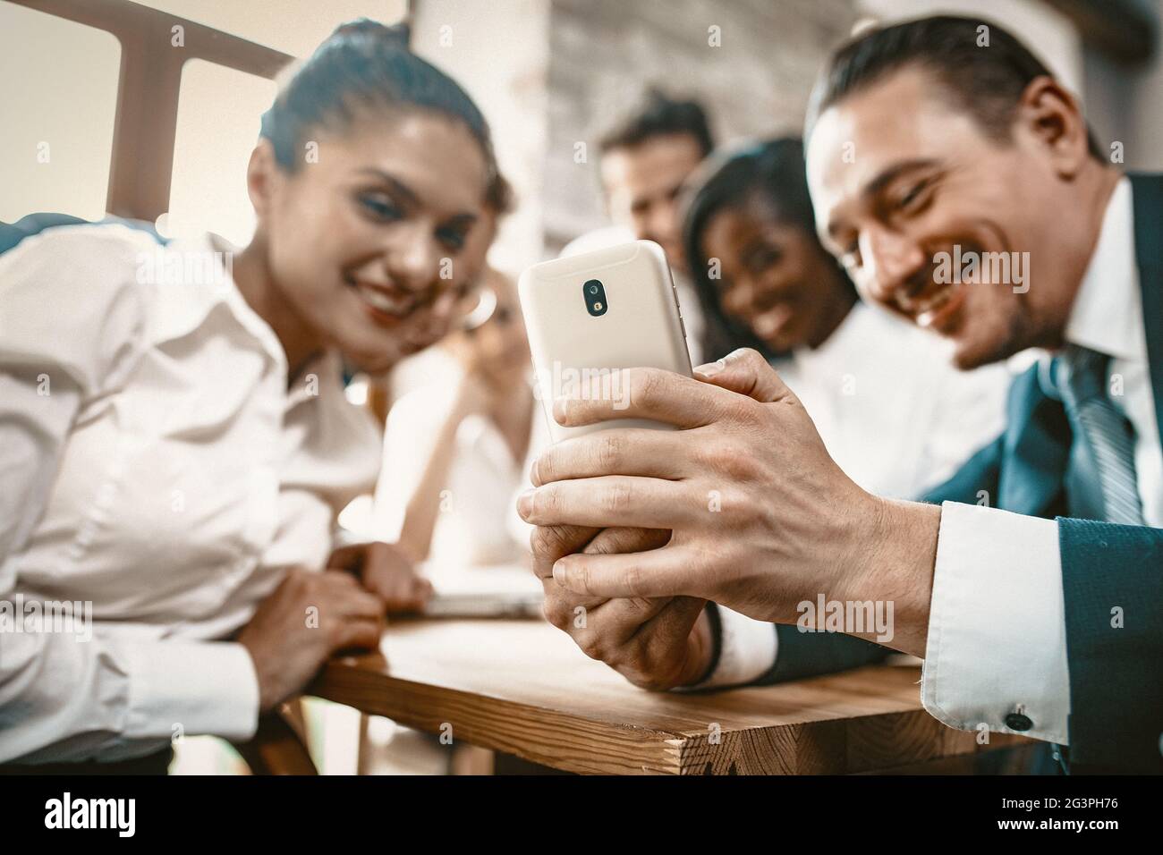 Diverse Team Of Employees Are Watching Photos In Mobile Phone Stock Photo