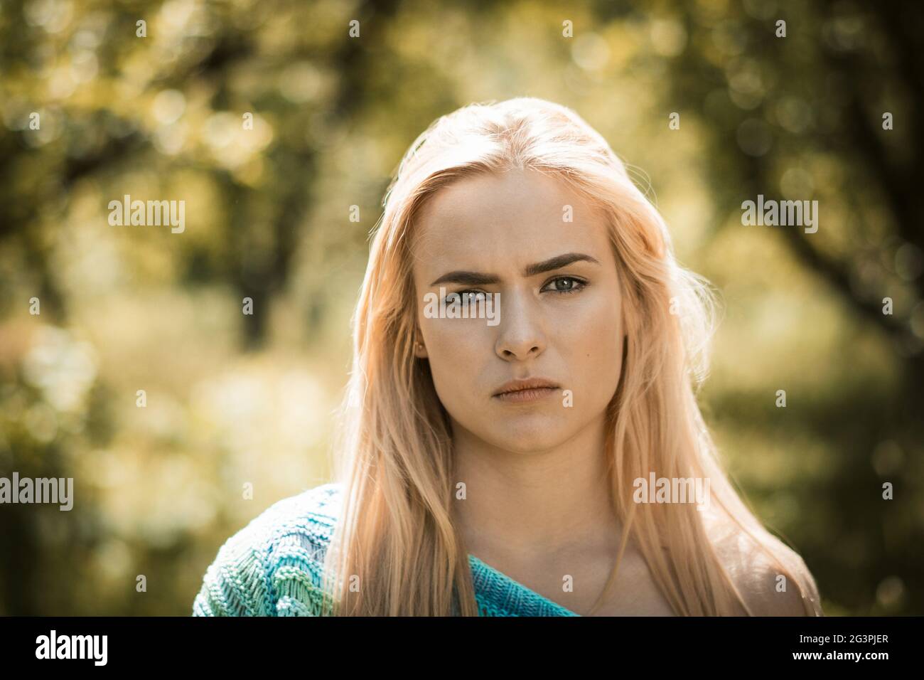 Beautiful young blond woman with perfect skin in park Stock Photo
