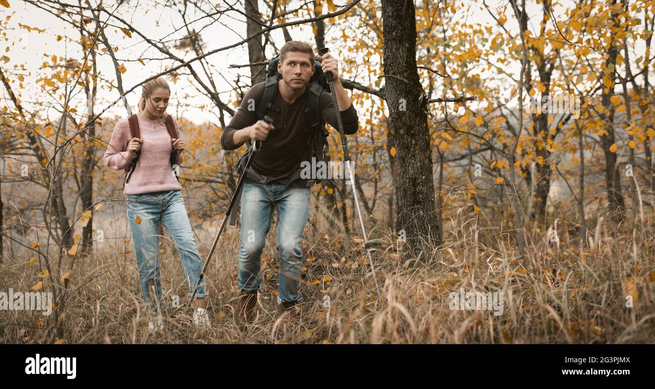 Loving couple makes their way through thicket Stock Photo