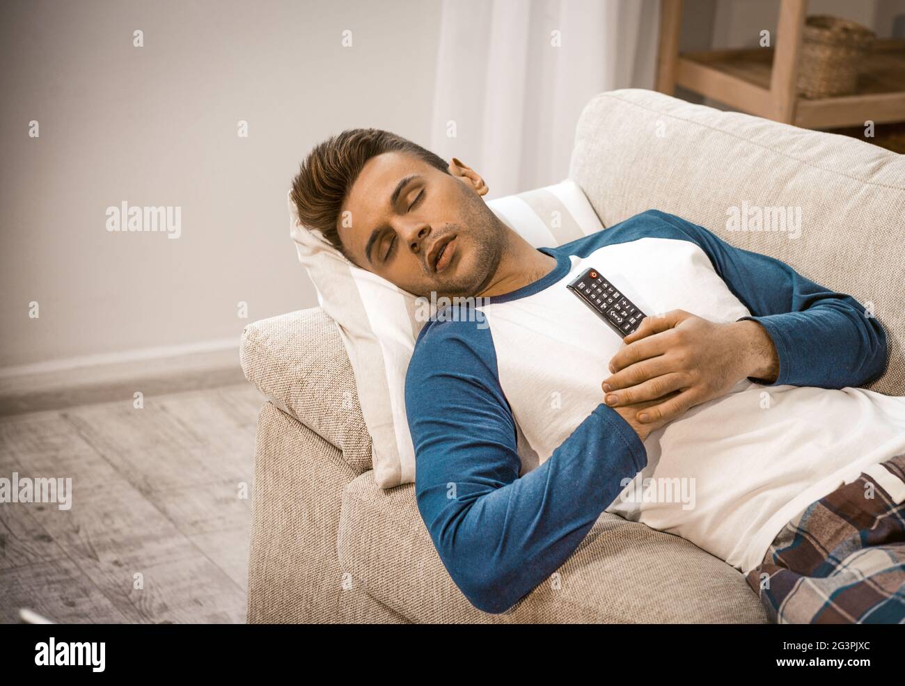 Sleeping Man Relaxing On Sofa Alone At Home Stock Photo