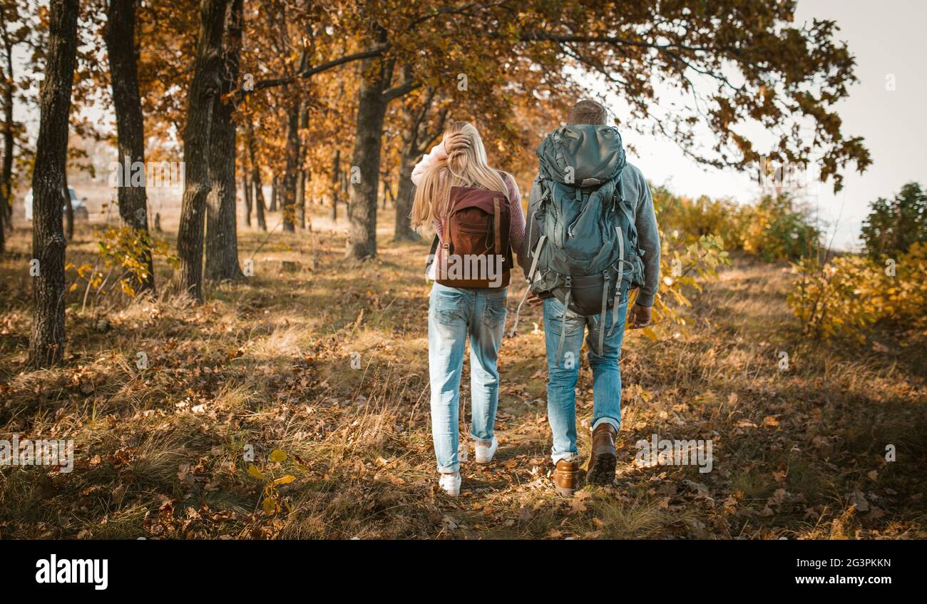 Hiking of Young Couple With Backpacks Holding Hands Stock Photo - Alamy