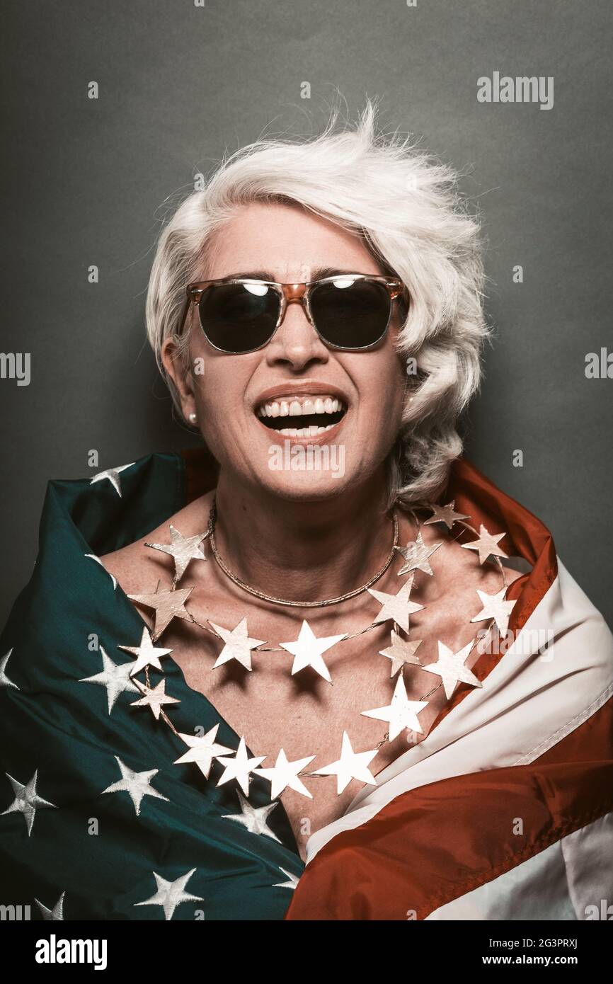 Laughing senior woman In sunglasses wearing American flag Stock Photo