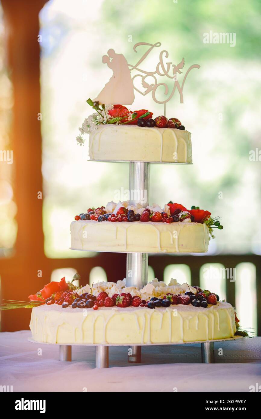 White wedding cake with flowers and berries Stock Photo - Alamy