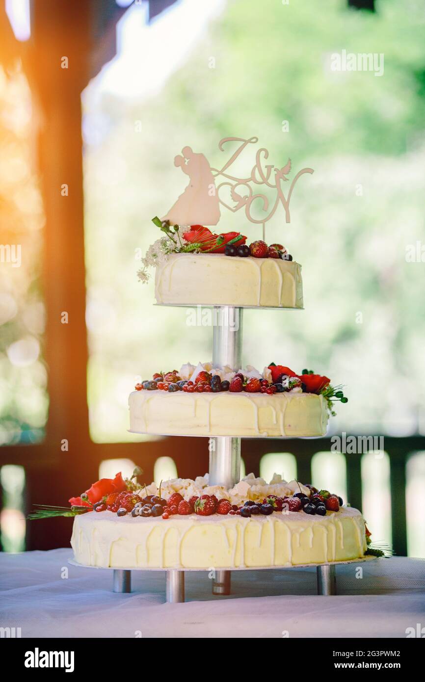 White wedding cake with flowers and berries Stock Photo - Alamy