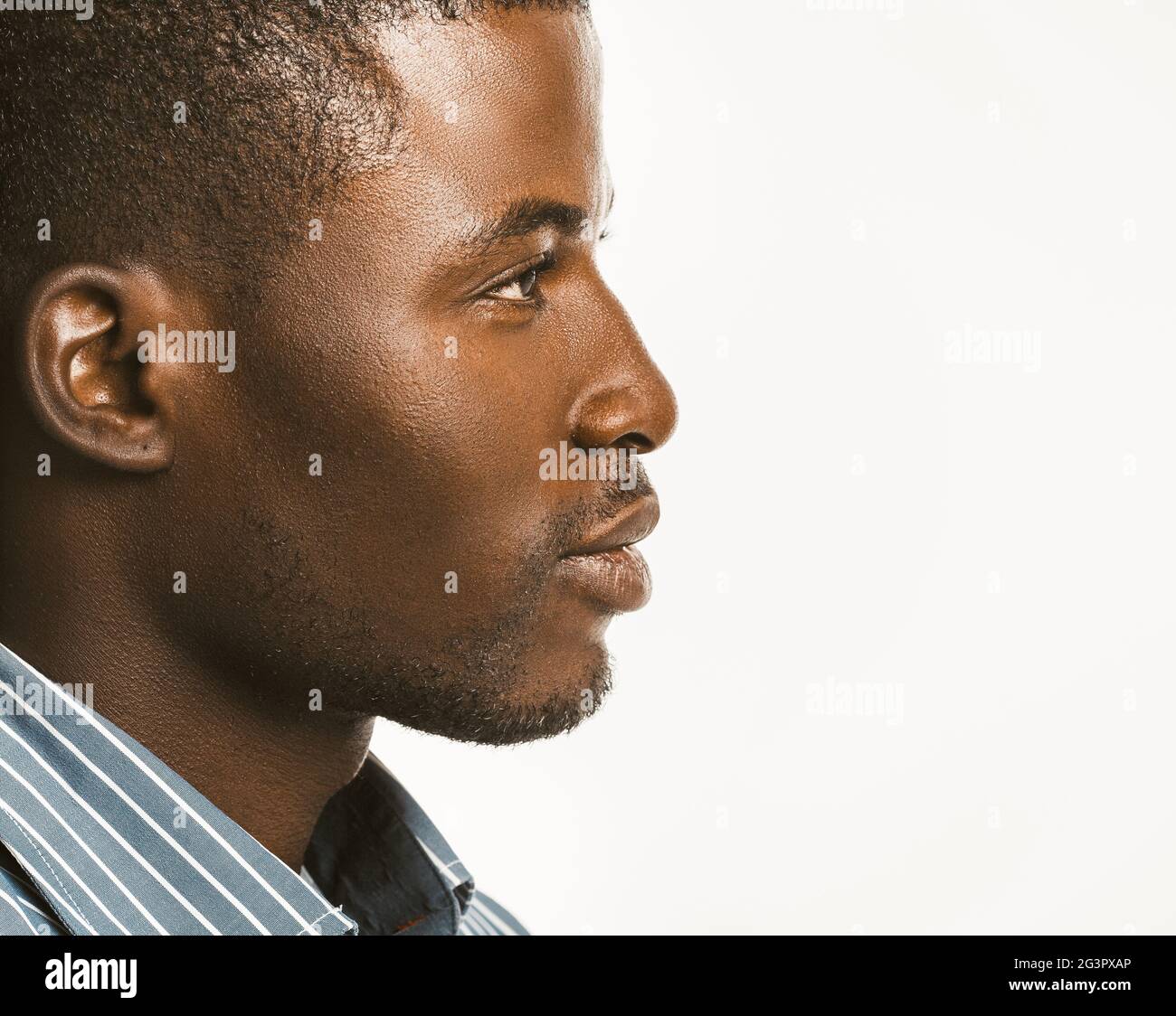 Serious African american man looks confident. Close up profile of Attractive Dark-skinned guy isolated on white background. Copy Stock Photo