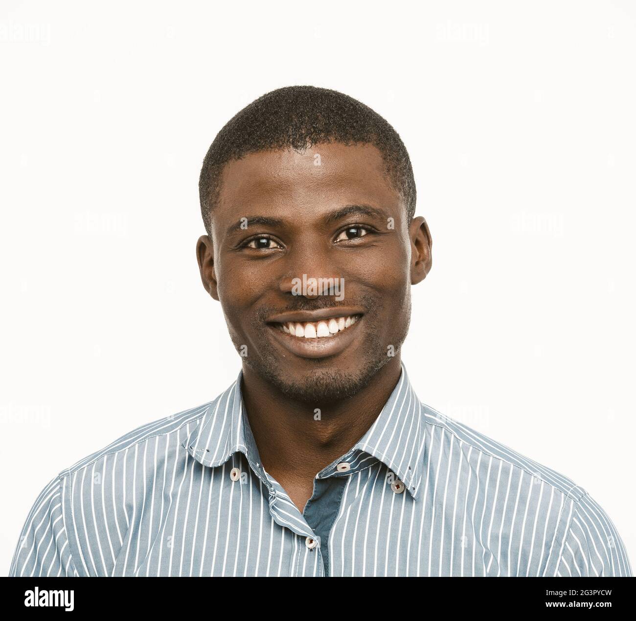 Toothy smiling African American man in shirt on white background. Portrait of positive dark-skinned guy in formal clothes. Toned Stock Photo