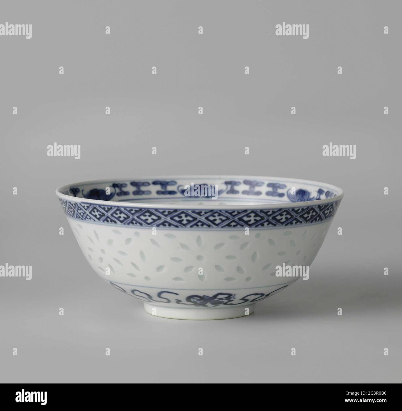 Bowl with Ornamental Borders and Translucent Rice-Grain Decoration. Bowl of  porcelain with flared wall, painted with underglaze blue. The wall is  decorated with glazed rice grain Ajourwerk; to the foot taoist symbols (