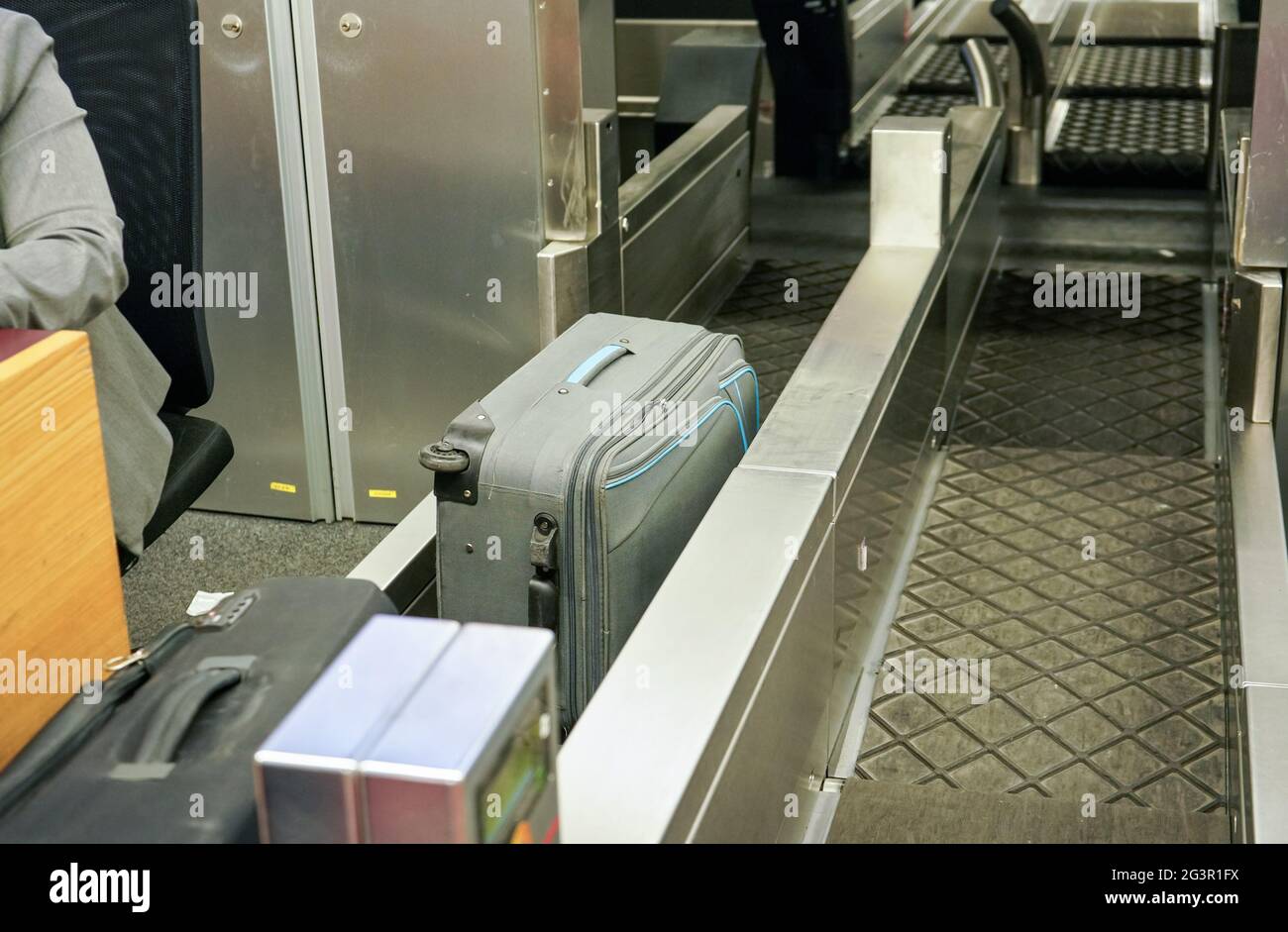 Checked in bags and luggage on transport belt of airport checkin desk