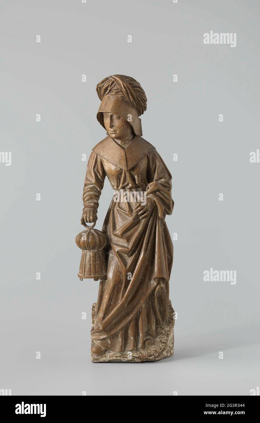 Holy woman with lantern. She stands on an ascending ground surface with the curved right leg something aside and with the head to the left. It bears the lantern in the right hand and holds up with the left-hand skirt, so that part of it depends on the forearm and to see it, as well as the blunt shoe points. The woman wears a stested hood and a turban over it. The covered with long sleeves, around the drug, has a wide flat collar. Stock Photo