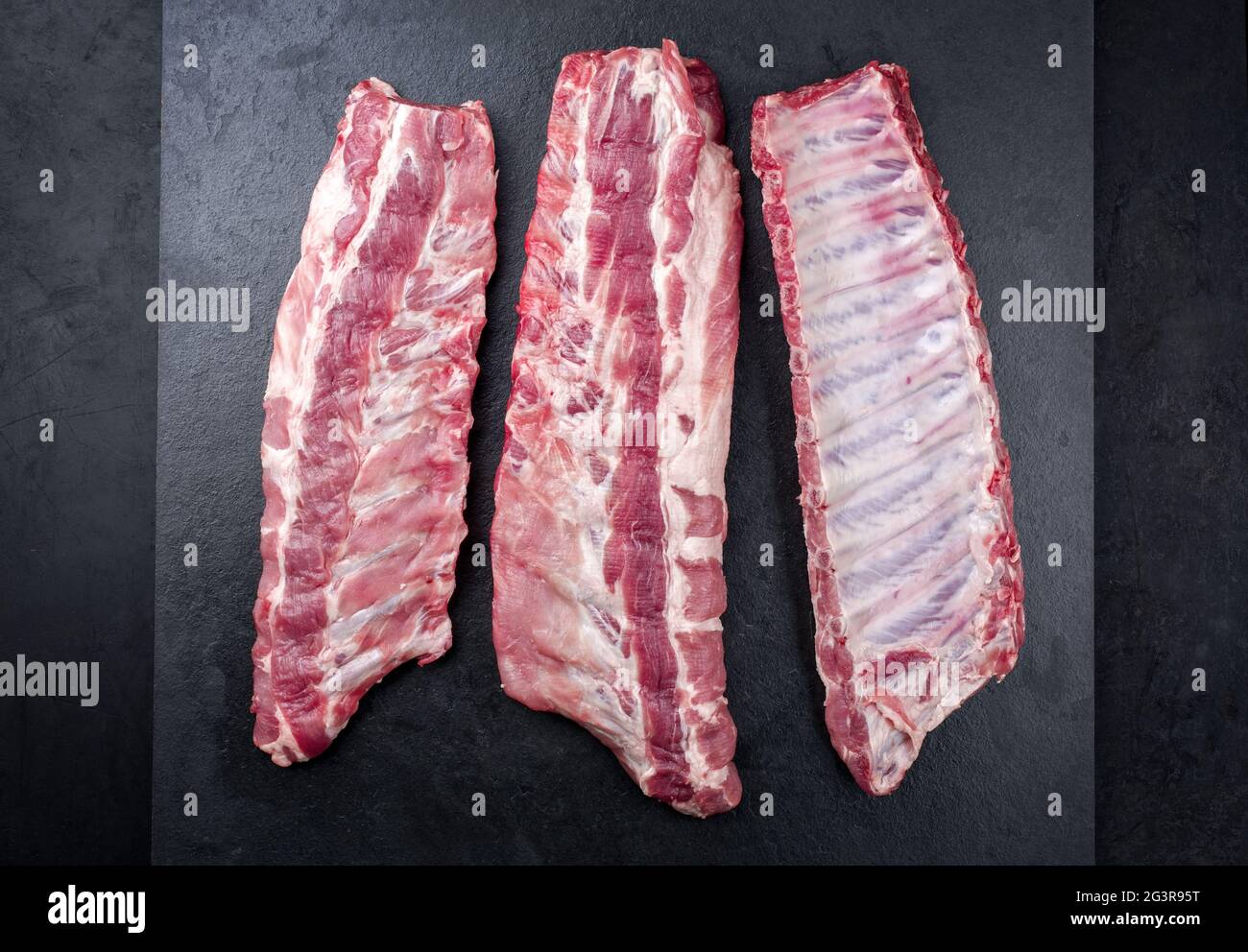 Raw pork spare loin ribs St Louis cut offered as top view on an old ...