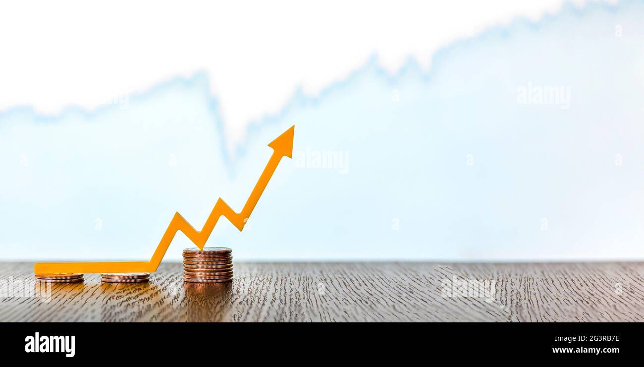 Volatility, change in the value of securities, volatility of stock markets. Arrow pointing upwards on stacks of coins, banner, place for text Stock Photo