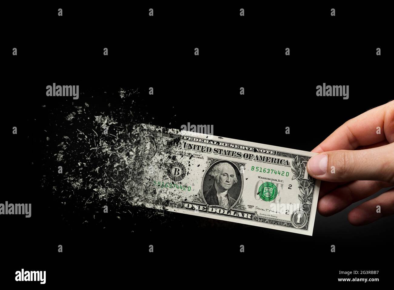 Inflation, dollar hyperinflation with black background. One dollar bill is sprayed in the hand of a man on a black background. The concept of decreasi Stock Photo