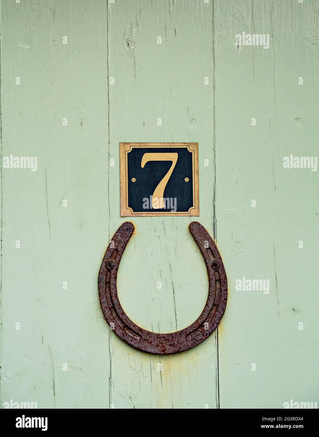 Lucky horseshoe and lucky number seven on street door Stock Photo