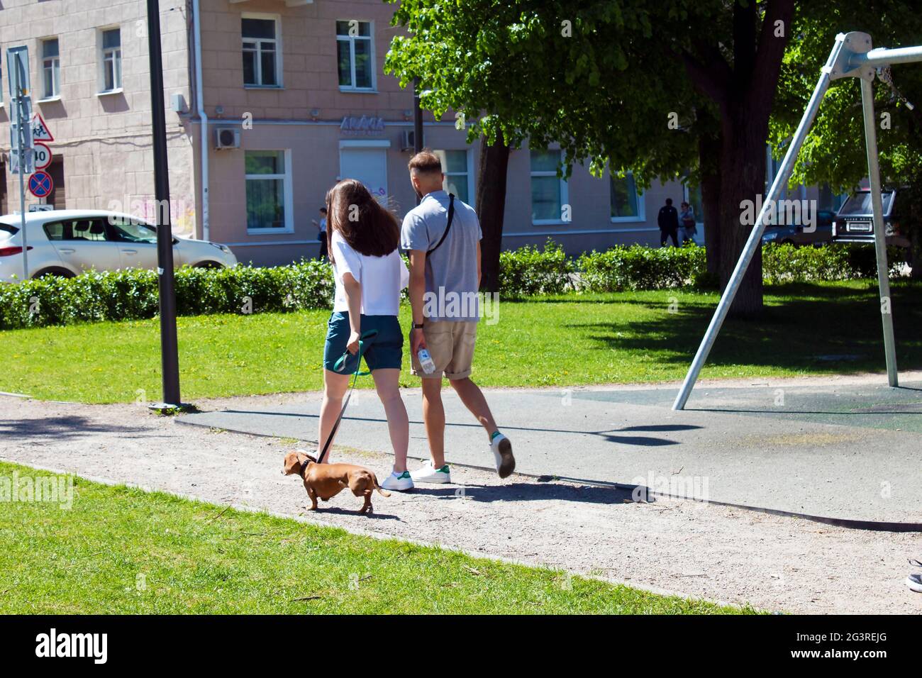 Young couple walking down the street with a dog Stock Photo